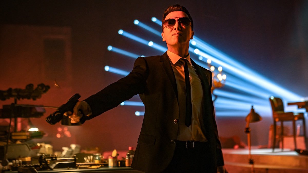 Donnie Yen's Caine in a blacksuit points a gun in John Wick: Chapter 4