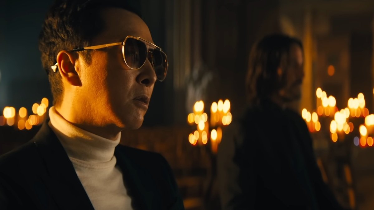 Caine in sunglasses sits in a church with John Wick opposite him in John Wick: Chapter 4, one of the best characters of 2023