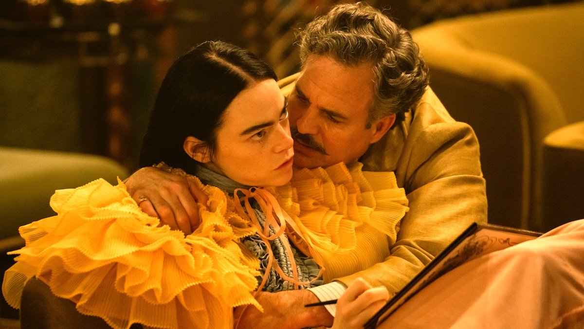 MArk Ruffalo and his mustache holds Emma Stone in a puffy dress in an image from Poor Things